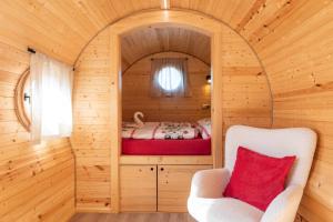 a bedroom with a bed in a wooden cabin at Wellnes Hříbek in Dyjákovice