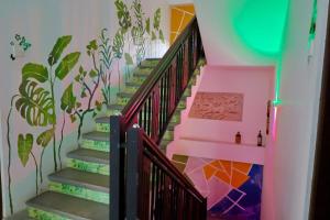 a staircase with a mural of plants on the wall at Ceylon Heart Villa in Unawatuna +17 photos