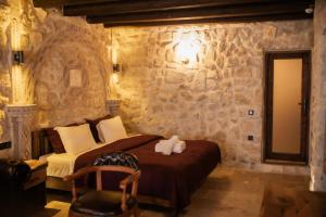 a bedroom with a bed and a stone wall at Rose Moon Cave in Macun Çiftliği