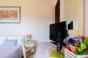 ein Schlafzimmer mit einem Bett und einem Tisch mit einem Fernseher in der Unterkunft Li Suari Club Village in San Teodoro
