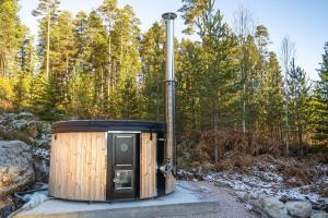 un retrete de madera sentado en medio de un bosque en Jörd Hytte - 8p - With Sauna & Hot Tub, en Vradal