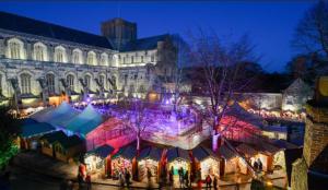 a christmas market in front of a large building at Winchester Wessex Hotel by Sunday in Winchester