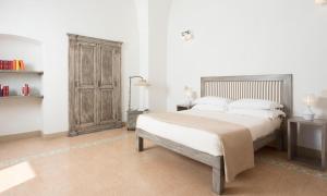 a bedroom with a bed and a wooden cabinet at Relais San Martino - Salento in Taviano