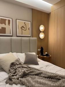 a bedroom with a bed with a blanket on it at KL Desa Park City Muji Suite in Kuala Lumpur +4 photos