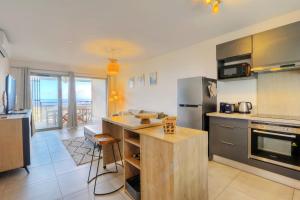 una cocina con una isla de cocina con encimera en Le Nocéa - apt T3 Saint Leu, en Saint-Leu 21 fotos más