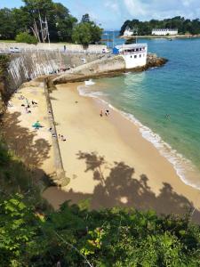a beach with people on the sand and a bridge at Port Rhu Appartement 4 personnes in Douarnenez