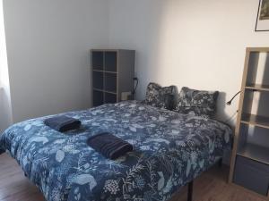 a bedroom with a blue bed with pillows on it at Port Rhu Appartement 4 personnes in Douarnenez