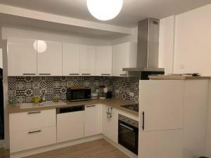 杜瓦讷内Port Rhu Appartement 4 personnes的厨房配有白色橱柜和白色冰箱