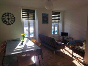 a living room with a table and a couch and windows at Port Rhu Appartement 4 personnes in Douarnenez