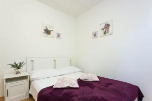 een slaapkamer met een bed met een paarse deken bij Robinson Delphinus in Gdinj