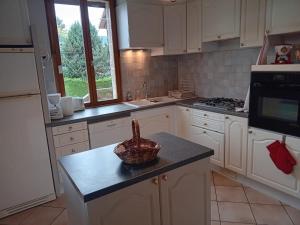 a kitchen with white cabinets and a basket on a counter at La Vie en Rose et Azur in Cluses