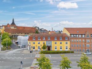 a city with a yellow building and a street at Hotel Garni in Svendborg