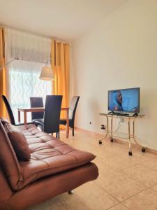 un soggiorno con un divano e un tavolo con un computer portatile di Happy House - Central Apartment a Faro