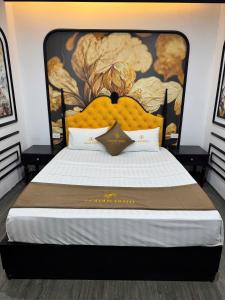 a bedroom with a large bed with a large headboard at Golden Hotel in Hanoi
