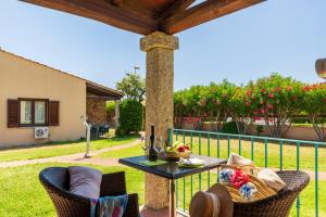 eine Terrasse mit Tisch und Stühlen auf einem Zaun in der Unterkunft Li Suari Club Village in San Teodoro