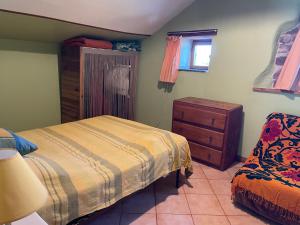 a bedroom with a bed and a dresser and a window at Gîte des Monts in Saint-Izaire