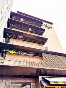 a tall building with a akoyaknife sign on it at Arigato Stay Kanazawa Ekimae in Kanazawa