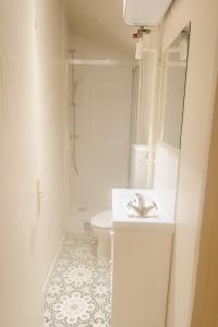 a white bathroom with a sink and a toilet at Appartement 4 Chambres proche commodités Ideal grande Famille et Groupe de professionnels Proche Paris in Puteaux +2 photos