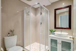 a bathroom with a shower and a toilet and a sink at #5B on Brassie in Lakeside