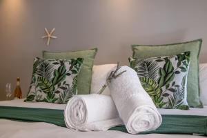 two rolls of towels on a bed with pillows at #5B on Brassie in Lakeside