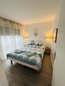 Un dormitorio con una cama con un edredón azul y blanco. en Appartement terrasse entre Paris et Disney, en Bry-sur-Marne