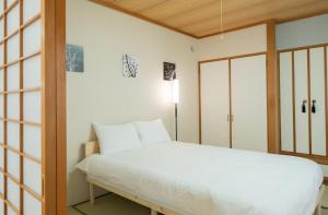 Postel nebo postele na pokoji v ubytování Asahimachi House