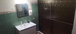 a bathroom with a sink and a mirror and a shower at Boquete Guest House in Puente Cochea