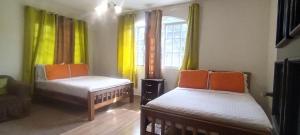 a small room with two beds and a window at Boquete Guest House in Puente Cochea