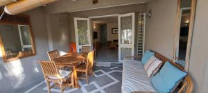 a porch with a couch and a table and chairs at Kenville in Cap Malheureux