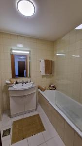 a bathroom with a sink and a bath tub and a mirror at Casa Nóbrega in Caniço