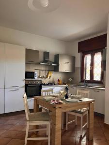 Isola SacraにあるMaison Gaia a due passi dall'aeroportoのキッチン(木製のテーブル、椅子付)