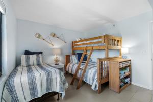 a bedroom with two beds and a bunk bed at Shorehom by the Sea 51 in New Smyrna Beach +49 photos