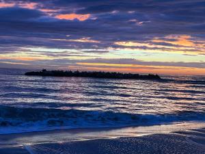 a island in the ocean at sunset with a beach at La Fabbryca in Porto SantʼElpidio