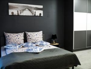 a bedroom with a bed with blue pillows and a pier at Apartament Oslo in Pniewy