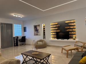 a living room with a couch and a table at Hermes Apartment - Athens Int Airport in Artemida
