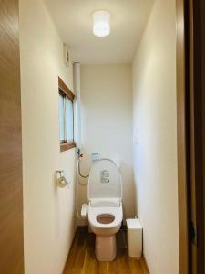 a small bathroom with a toilet with the lid up at NisekoSnowHouse in Abuta +11 photos