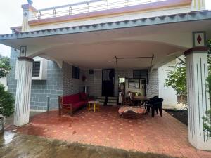 an outdoor patio with awning and tables and chairs at 2BHK Nature Stay in Wādhiware