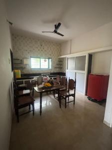 a living room with a table and chairs and a ceiling fan at 2BHK Nature Stay in Wādhiware