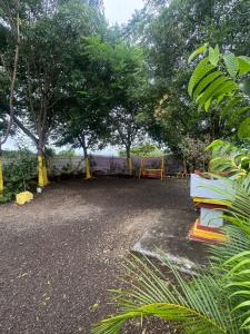 a park with a bench and trees and a fence at 2BHK Nature Stay in Wādhiware