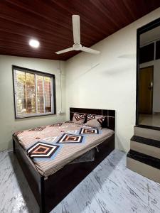 a bedroom with a bed with a ceiling fan at 2BHK Nature Stay in Wādhiware