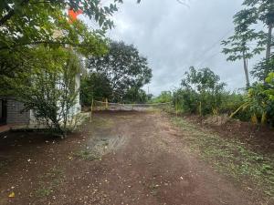 a dirt road next to a house with a fence at 2BHK Nature Stay in Wādhiware +1 photo