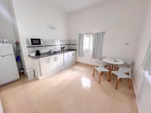 a kitchen with a table and a white refrigerator at Refugio Del Corazón in Capilla del Monte