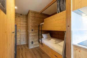 a small room with bunk beds in a wooden cabin at La Foret du Praz 501 in Courchevel +8 photos