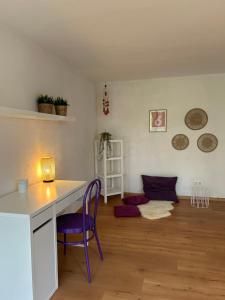 a living room with a desk and a purple chair at XXL Schlafzimmer in charmantem Villenanwesen in Heroldsberg
