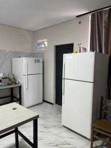 a kitchen with two white refrigerators and a table at Khando's Resort in Passanauri