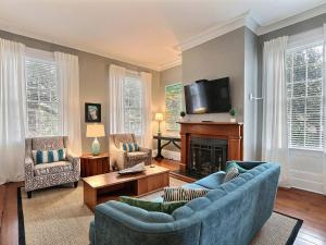 a living room with a blue couch and a fireplace at Mint Julep Estate in Savannah