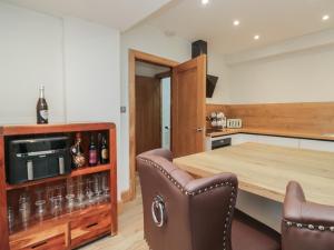 een keuken met een houten tafel en lederen stoelen bij Park View in Ambleside