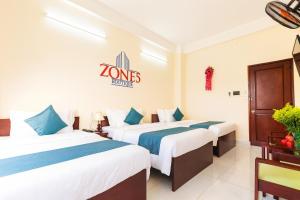 two beds in a hotel room with a logo on the wall at Zone 5 Boutique Hotel in Da Nang +20 photos