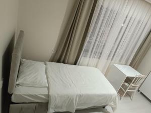 Un dormitorio con una cama y una ventana con una silla. en DENİZ BAYAN PANSİYON APARt, en Sivas