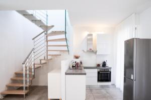 a kitchen with white cabinets and a staircase at The Rooftop in Bologna